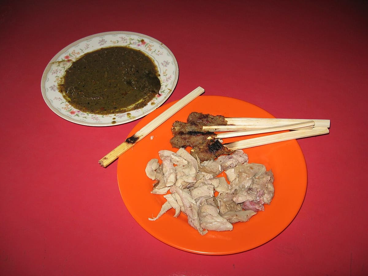 盘中的巴厘烤乳猪与沙爹串